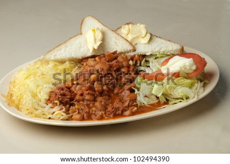 chili beans / Plate of chili beans. served as a meal with hash brown, salad, and bread.