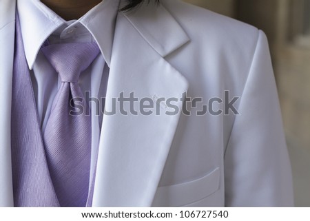 Tuxedo / Standing groom in a white  tuxedo. Image was taking during a wedding.