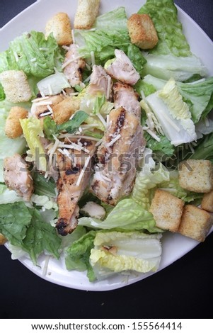 Caesar's chicken salad serve on a black plate. This image was shot with a canon mark II.  / Caesar's chicken salad.