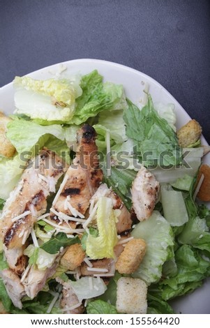 Caesar\'s chicken salad serve on a black plate. This image was shot with a canon mark II.  / Caesar\'s chicken salad.