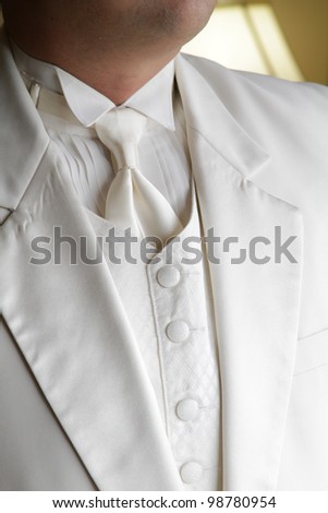 tuxedo / Standing groom in a white tuxedo. Image was taking during a wedding.