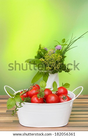 tomatoes in a basket and a decorative bouquet of herbs in a vase