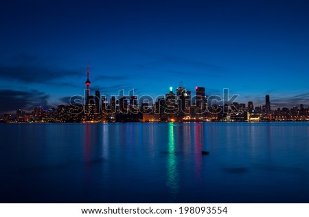 Toronto cityscape at night with reflections over the lake