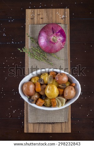 Roasted vegetables dish with potatoes, carrots, mushrooms and onion
