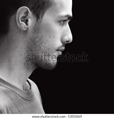 Black and white profile portrait of a young man - isolated over black