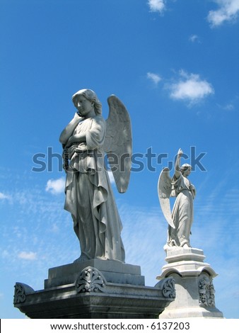 stock photo Detail of winged angel statues against blue sky