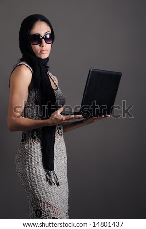 Portrait of young fashion female holding laptop
