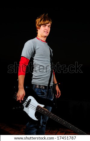 Portrait of young trendy electric bass player isolated