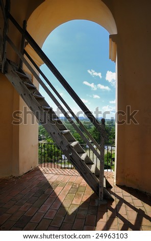 A view of rustic wooden staircase with tropical landscape in the background