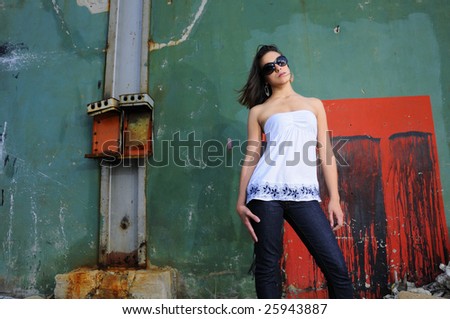Portrait of young female fashion model posing against grunge abstract background