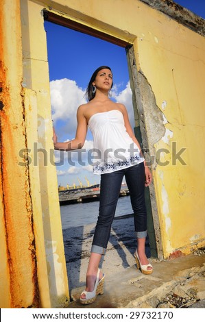 Portrait of trendy teen fashion female posing on urban grunge background