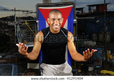 Portrait of african hispanic guy standing with attitude on grunge rooftop with cuban flag