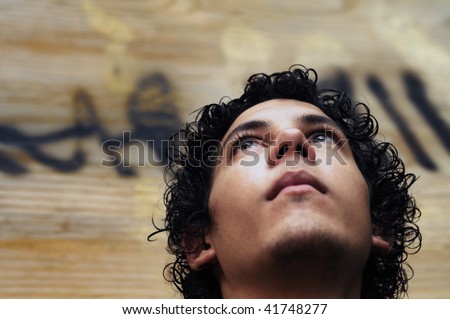 Portrait of young hispanic teen boy against grunge background