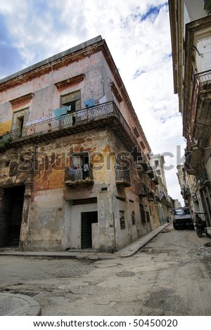 Corner with eroded building facade against blue sky in San ignacio street, Havana, cuba