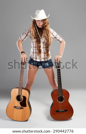 Sesy cowgirl in cowboy hat with acoustic guitar