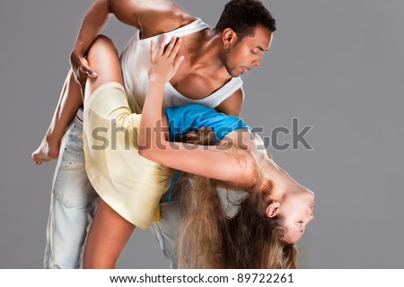 Young couple dances Caribbean Salsa, studio shot