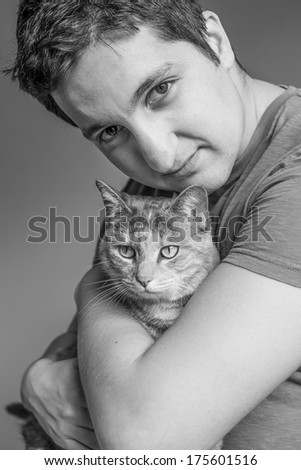 Black and white image of a handsome Turkish man holding a tortoiseshell-tabby cat