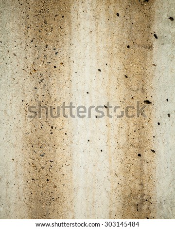 Textured background of two dirty brown rust stains running down a grey concrete wall