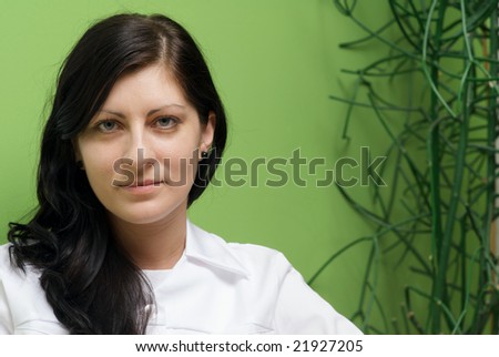 cute brunette in green medical gown and a stethoscope in an hospital