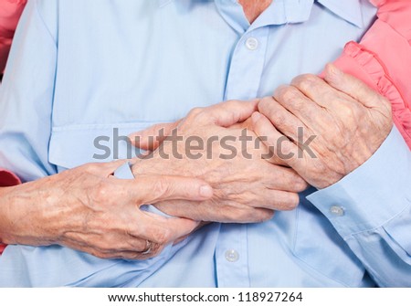 hands of elderly pair by CU, hugs