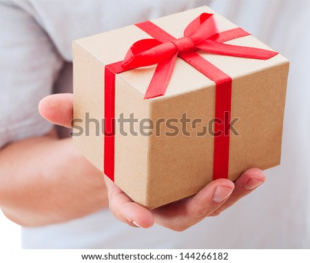 male hand holding gift with ribbon.