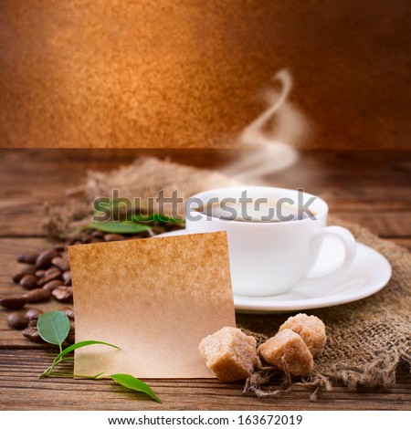 Cup of warm coffee, sugar cubes and coffee beans on wooden surface. Free space for your text.