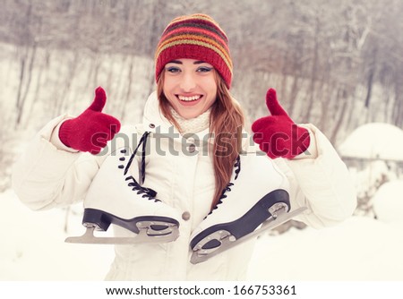 Portrait of beautiful cheerful Woman with Skates in the Park  Winter. On the Rink. Hand Sign Ok,Thumbs Up.