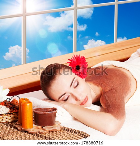 Beautiful Young Woman Getting Massage Facial and Body in Spa Salon. Treatment Cosmetics Beauty Care Body Herbs Surrounded by Flowers