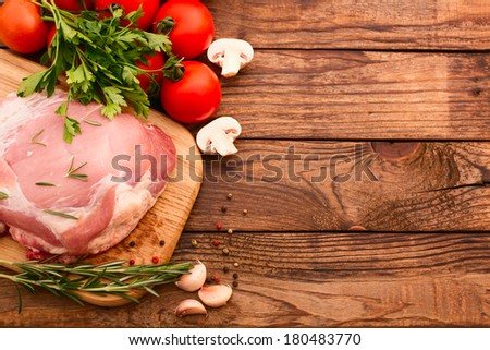 Food. Sliced pieces of raw Meat for barbecue with fresh Vegetables and Mushrooms on wooden surface. Meat Raw Steak. Beef Steak BBQ. Tomatoes, peppers, spices for cooking meat.