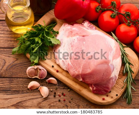 Sliced pieces of raw Meat for barbecue with fresh Vegetables and Mushrooms on wooden surface. Meat Raw Steak. Beef Steak BBQ. Tomatoes, peppers, spices for cooking meat.