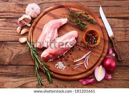 Raw meat for barbecue with fresh vegetables on wooden surface. Food, meat raw steak, beef steak bbq, spices for cooking meat. Free space for text.