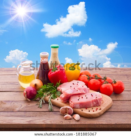 Sliced pieces of raw Meat for barbecue on wooden surface, menu cooking recipes. Food, raw steak, beef steak bbq, tomatoes, peppers, spices for cooking meat. Collage sky.