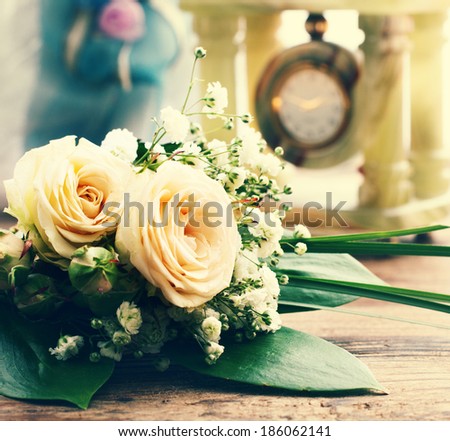 Bridal bouquet of white flowers on wooden surface. Summer wedding day, unusual designer florist bouquet of delicate roses. Free space for text.
