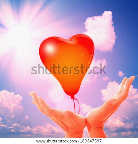 Retro love balloons on blue sky. Sky background with fluffy white clouds. Sunny day at nature. Man\'s hands reach for sky, prayer, worship, praise, admiration. Concept of peace, tranquility, love