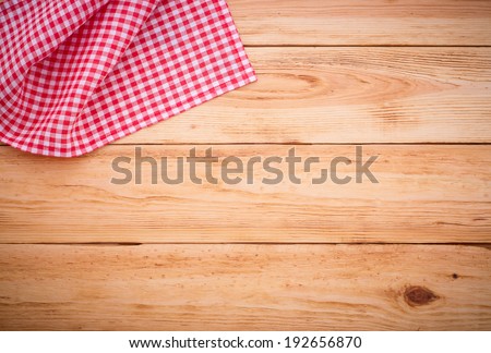 Wooden table covered with tablecloth. View from top. Empty tablecloth for product montage. Free space for your text