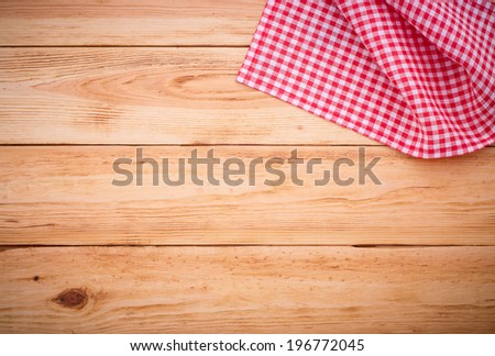 Wood texture background. Wooden table covered with tablecloth cloth checkered plaid red. View from top. Empty tablecloth for product montage for recording menu, recipe. Free space for your text