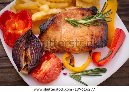 Food. Meat barbecue with vegetables on wooden surface. Meat steak. Beef steak bbq. Tomatoes, peppers, spices for cooking meat.