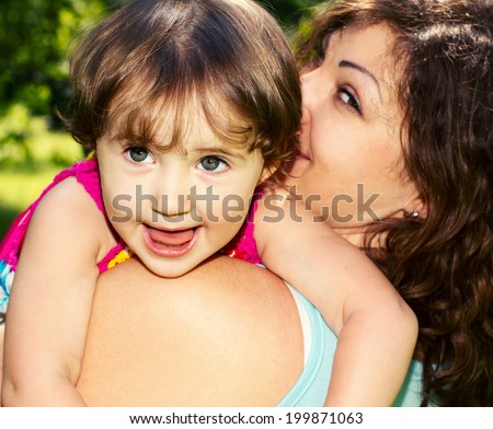 Portrait of a beautiful little girl close-up Face of a happy child. Little girl hugging her mother. Happy family.