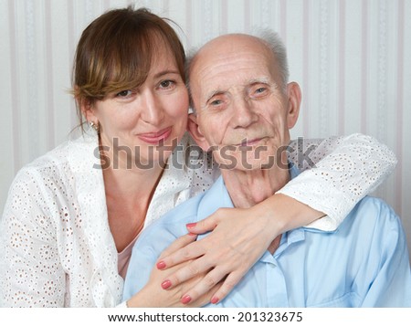 Elderly man and nurse at home. Kind doctor taking care of an old man in wheelchair. Concept of health care for elderly old people, disabled.