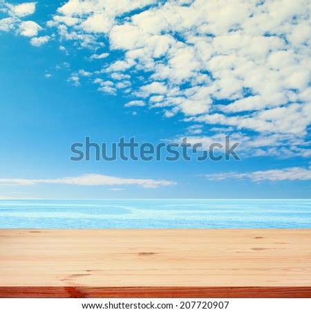 Blue sea and clouds on sky. beach and tropical sea. Empty wooden deck table with tablecloth for product montage. Sunny Day, Blue Sky with Clouds Free space for your text
