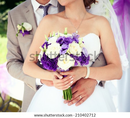 Happy bride and groom on their wedding. Wedding couple holding hands. Bride and groom holding hands. Wedding bouquet closeup. Fashionable toning. Selective focus