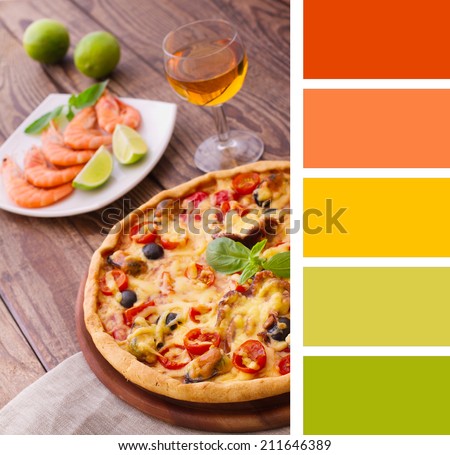 Pizza with seafood. Seafood Italian Pizza slice on wood dish (originality). Italian kitchen. Studio.  Background color palette with complimentary color swatches.