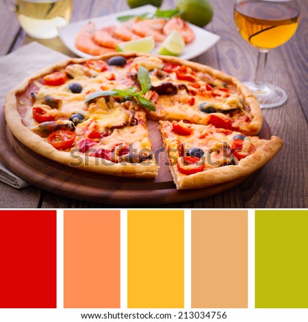 Dinner with white wine and shrimp. Pizza with seafood. Seafood Italian Pizza slice on wood dish (originality). Italian kitchen. Studio. Background color palette with complimentary color swatches.