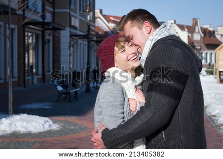 Portrait of young sensual couple in cold winter weather. Love and kiss. Young people. Snow lovers kiss city. Fashion clothing.Young people walking around the city in the winter