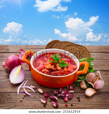 Ukrainian and Russian national Red Borscht with Bread closeup on Old Wooden Surface.  Soup for lunch. Food, meat, spices for cooking meat. Free space for text.