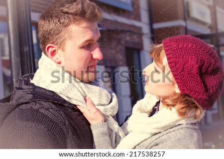 Young people walking around city in winter. Couple in cold winter weather. Love and kiss.  Snow lovers kiss city. Fashion clothing.