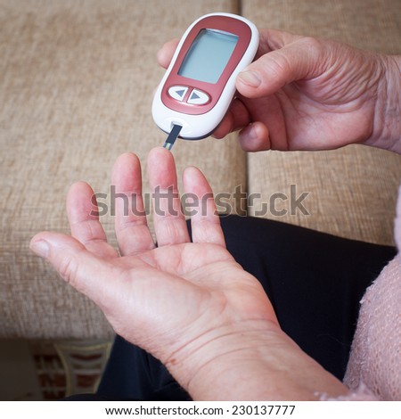 Woman testing for high blood sugar. Woman holding device for measuring blood sugar