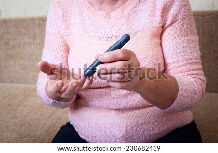 Woman testing for high blood sugar. Woman holding device for measuring blood sugar