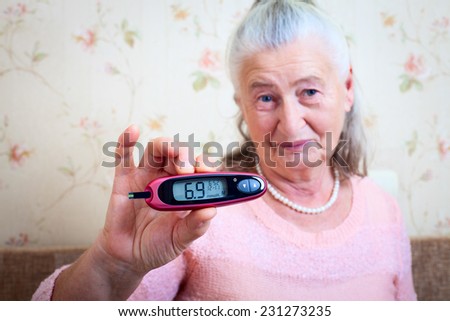 Disease diabetes. Woman testing for high blood sugar. Woman holding device for measuring blood sugar