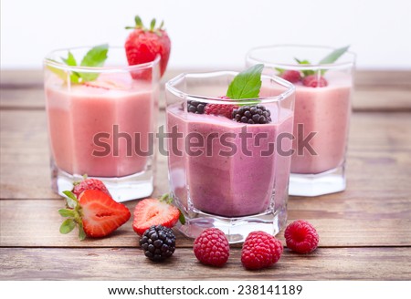 Drink smoothies four summer strawberry, blackberry, raspberry on wooden table. healthy lifestyle concept.